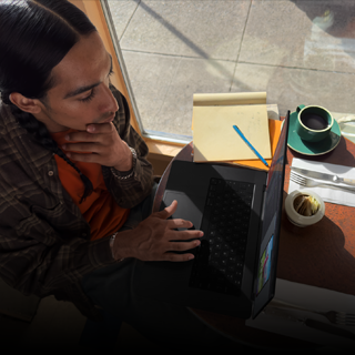 Persona trabajando en una MacBook Pro desconectada en una cafetería