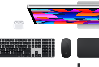 Vista superior de accesorios Mac seleccionados: Studio Display, Magic Keyboard, Magic Mouse, Magic Trackpad, AirPods y cable de carga MagSafe